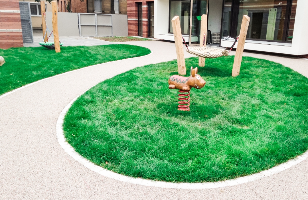 Spielplatz an einem Kindergarten mit Spielgeräten aus Holz und Terraway®-Belag Spielplatz an einem Kindergarten mit Spielgeräten aus Holz und Terraway®-Belag
