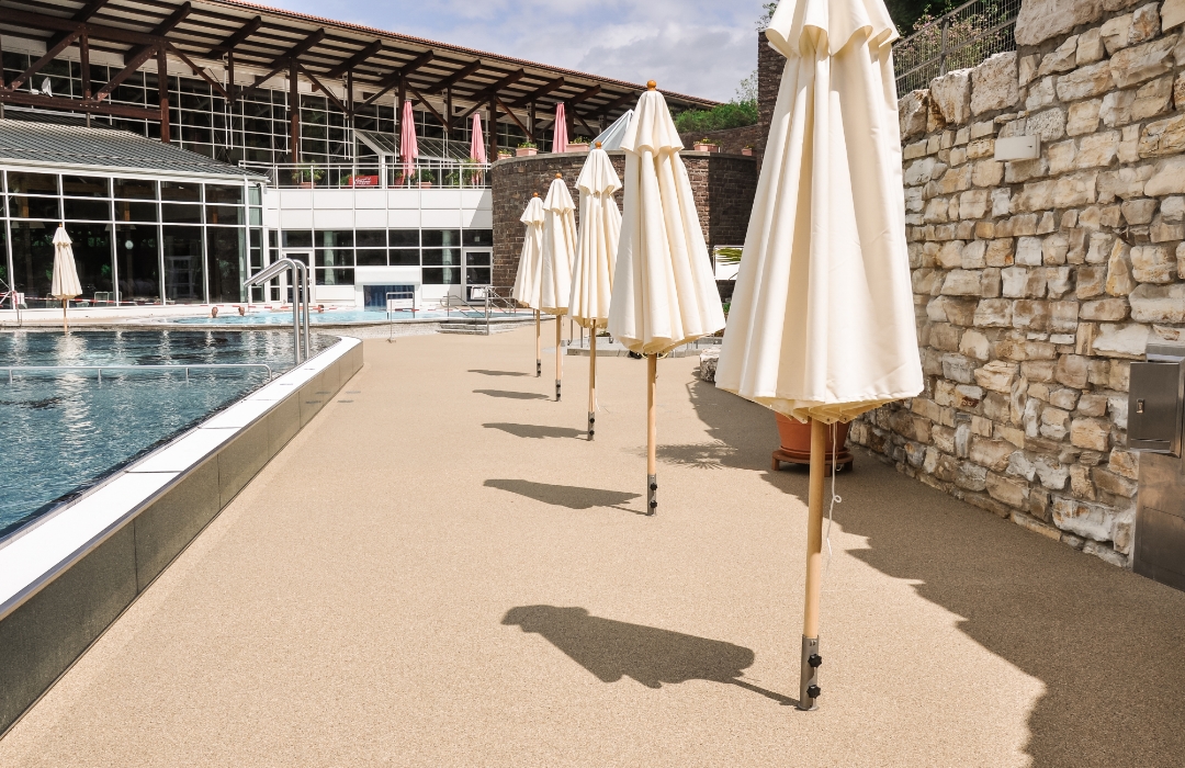 Freibad Dingolfing: Liegebereich mit Terraway®-Belag und zugeklappten Sonnenschirmen 